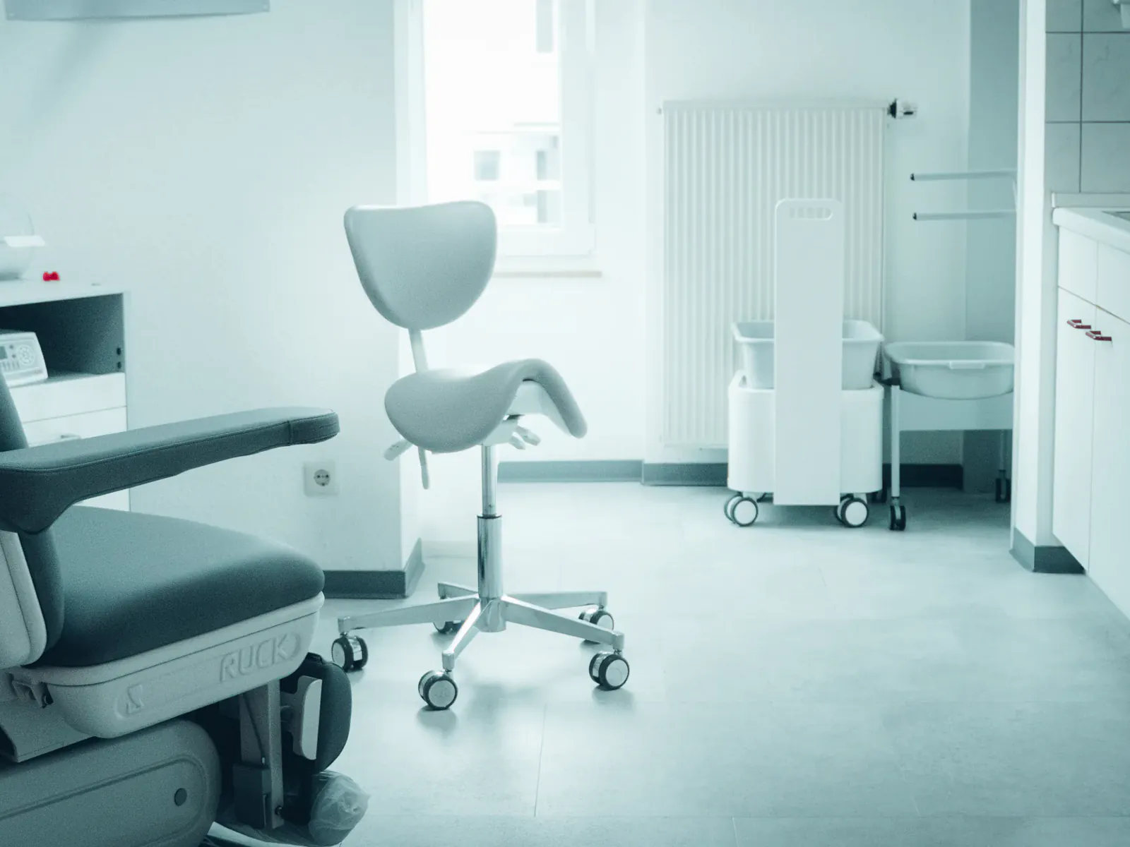 Behandlungsraum der Praxis Via Vitales mit Sattelhocker am Fenster